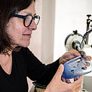 Anne Wenzel graviert ein kleines blaues Glas